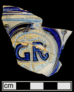 Gray-bodied salt glazed stoneware straight sided tankard with applied round medallion molded with crowned GR cipher of King George I (1714-1727) or King George II (1727-1760).  Incised with scroll-like motifs outlined in cobalt-blue.  Cordoned above medallion, from 18CV60.