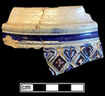 Gray-bodied salt glazed stoneware tankard with applied  hearts and diamonds.  Cobalt-blue and manganese under the glaze.  Rim diameter: 4.0”. Vessel probably dates to second half of 17th century, based on the applied and incised motifs with cobalt blue and manganese.