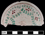Teapot lid with enamelled floral motif in red and green. 3.00” rim diameter from 18BC27.