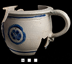 Gray-bodied salt glazed stoneware chamberpot  with applied rampant lion and stamped rosettes outlined in cobalt-blue  under the glaze.  Cordoned rim and base. Rim diameter. 6.70”; Base diameter: 5.50”; Vessel height:  5.75”; Object ID: 2602.