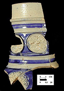 Gray-bodied salt glaze stoneware jug with applied (sprigged) floral motifs with cobalt blue painted under the glaze.  Cordoned neck. 2.25” rim diameter. Lot numbers:  18CV271-8, 83, 86, 146, 234, from 18CV271.