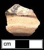 Base sherd of indeterminate hollow vessel.  Note the area of damage to the glaze in the upper center of the sherd where the white slip and brown slip combing are visible. Base diameter: 3.00”, Lot 229, from 18CV169.