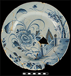 Plate painted in blue with floral sprays and a large central peony, a fence, and bamboo along the upper right side from the Brookes Inn 18PR386.