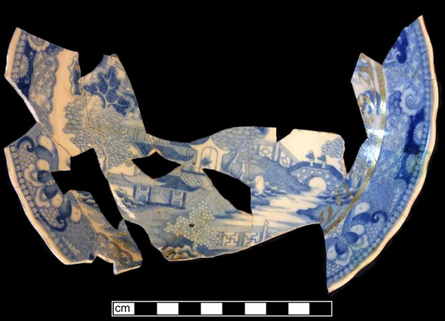 English soft paste porcelain plate printed underglaze in the Two Temples pattern (Copeland 1980).  The plate also has gold gilt applied over the glaze - from 18BC33. 