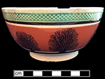 Common-shape pearlware bowl with mocha decoration against orange slip.  Green-glazed diamond rouletted rim. 6.25” rim, 3.125” vessel height.
