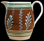 Barrel-form jug with vertical tri-colored "twigs" alternating with blue squiggles and green-glazed herringbone rouletting, c. 1810, 7 inches in height - from a private collection.