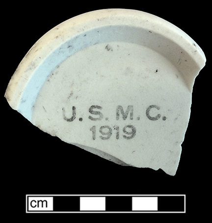 Mug. Unglazed bisque waster. Base diameter: 3.5”; 6.3 m thick. Printed mark for United States Marine Corps 1919 on underside of vessel.