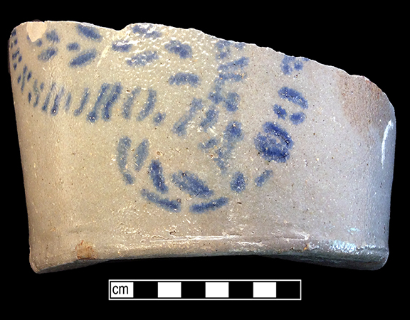 Grey-bodied salt glaze stoneware hollow vessel  with stencilled cobalt motif. Base diameter: 5.75”, Vessel #:7. This vessel was made in Greensboro, Pennsylvania by James Hamilton Company, in business between 1850 and 1880 (Greer 1981:174). 18BC56