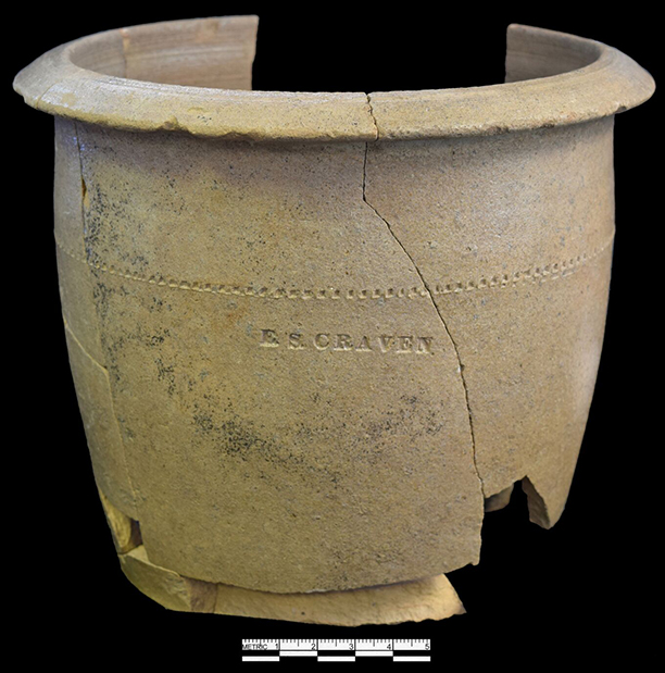Grey bodied salt glaze stoneware bowl or milk pan with impressed maker’s mark “E.S. Craven”. Enoch Craven (1810-1893) likely started producing wares in the early nineteenth century (Hatch et al. 2017: 81). This pan form, with a flat base and sloping sides, was the “universal form of bowl until after about 1860” (Greer 1981:97).