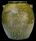 Ten-Gallon Alkaline-Glazed Stoneware Jar, Possibly Daniel Seagle, Lincoln County, NC origin, circa 1840, large-sized, rotund jar with thin, semi-rounded rim, and curved lug handles, the surface covered in a mottled green alkaline glaze with heavier glaze runs at the handle terminals - from a private collection. 