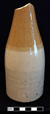 Tan bodied stoneware beer or ginger beer bottle with white Bristol glaze on lower 2/3 of vessel and ferruginous slip on neck and shoulders. Approximately 8” height, vase diameter: 3.0", from 18BC27. 