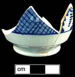 Pearlware painted underglaze blue-on-blue grid motif London shape cup with 3.75” rim diameter and matching saucer. There were two matching cups and one matching saucer in the privy assemblage. Images from left to right: London shaped cup; matching saucer; flower motif inside of cup; mark on bottom of plate; mark on bottom of cup