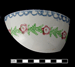 Cut sponge decorated bowl with floral pattern and scalloped rim motif.