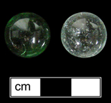 Private collection - Machine made glass marbles.Clear or transparent marbles were produced from the 1920s to the present (Randall and Webb 1988:35).  Single color marbles that are transparent, with occasional minor swirling in  glass from incomplete mixing. Donated to MAC Lab from private collection - click image to see larger view.