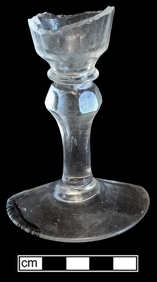 Colorless leaded stemmed glass with conical bowl, plain stem and folded foot. Empontilled. Rim diameter: 2.50”; Foot diameter: 2.50”; Vessel height:  4.50”. Lot 186-64B. 18BC66