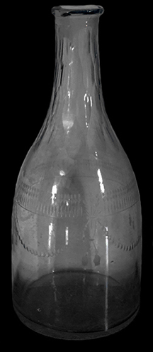 Colorless soda lime glass taper shaped decanter.  Wheel engraved swag motif. Cut flutes along neck. Empontilled flat base and ground interior bore. 9” vessel height; 3.75” base diameter; 1 2/8” lip diameter. Possibly Amelung New Bremen Factory 1784-1795 (see McKearin and McKearin 1989: Plate 42). Similar to decanter shown on right from a private collection. 18BC27-F30