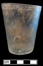 Tumbler of colorless soda lime glass with engraved wavy line on rim and partial floral motif on side. Empontilled. Rim diameter: 3.00”, Base diameter: 2.00”, Vessel height: 3.75”. Lot  187-39A. 18BC66