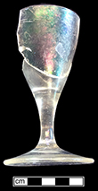 Colorless soda lime glass cordial glass. Funnel shaped bowl with plain straight stem and conical foot. 3.75” tall , 2” rim diameter, 2.25” base diameter. Lot 455. Plain stems common c. 1730-1775 (Bickerton 1986:19). 18BC27-Lot455