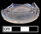 Colorless soda lime glass, probable tumbler. Fluted/paneled/arched at base. 2.25” base diameter. 18CV13