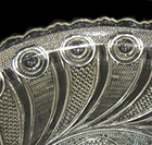 Colorless leaded glass press molded oval dish with peacock feather motif and scalloped rim. Dimensions:7.00” x 5.00” x 1.25” tall. Lots 529, 531, 532, 533, 535.Early period pressed glass, circa 1827-1840. This motif is also sometimes called “horn of plenty”. Shown on right: Peacock feather motif on a different pressed glass vessel for illustration purposes.