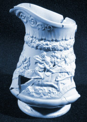 Blue molded jug with scene of horse and rider.