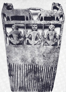 Carved bone comb with ornate top, decorated with three seated figures and two horses.