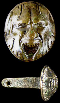 Metal butt cap of a pistol, decorated with carved humanlike face