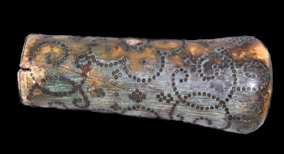 Cylindrical object that is bulbous on one end. Decorated with a floral pattern and C-scrolls.