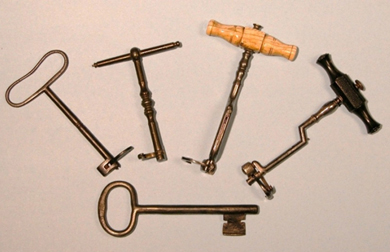A group of five dental keys. Two have the appearance of old fashioned keys and three look like old fashioned corkscrews.