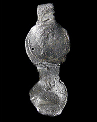 Figure 4 Double faced lead cloth seal with the impression of a head on the top face on a black background and a 1 cm scale. 