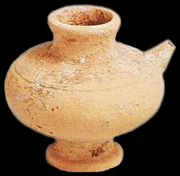 Ceramic cup, with a small spout on the right hand side.