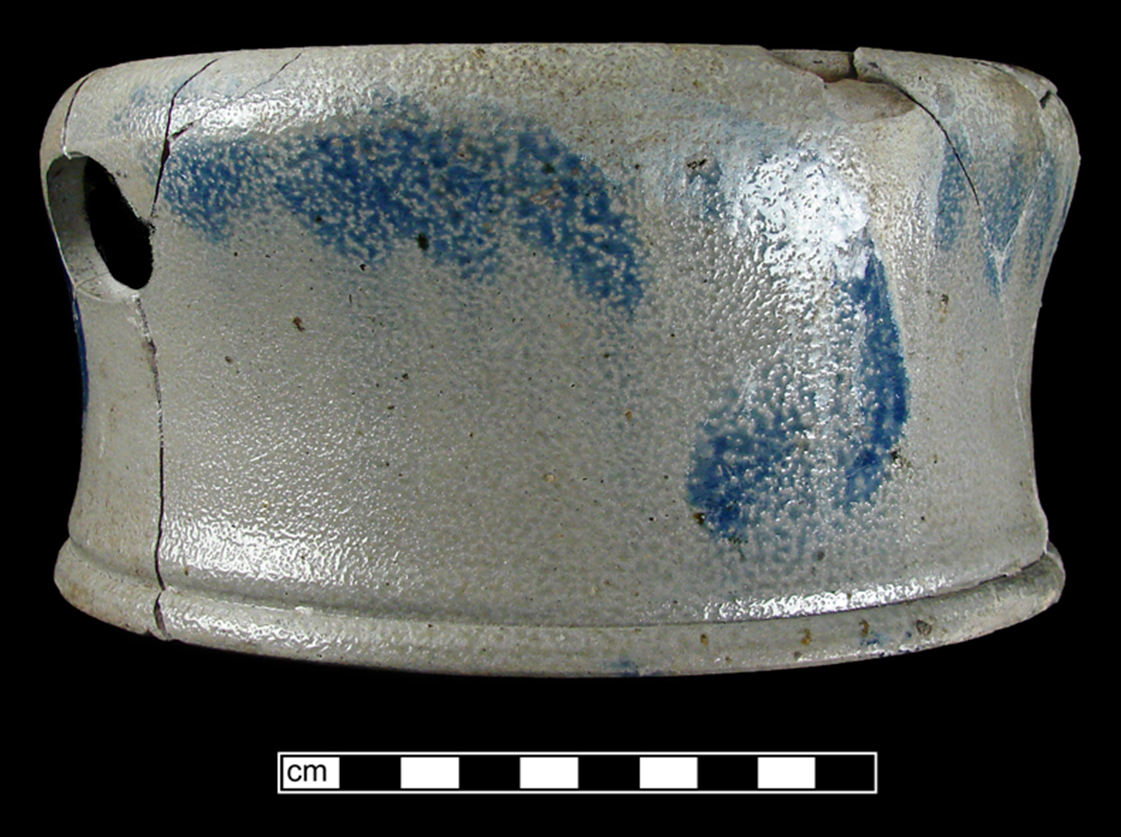 Side view of grey spittoon painted with blue swirls and showing round hole on side used to pour out tobacco juice.