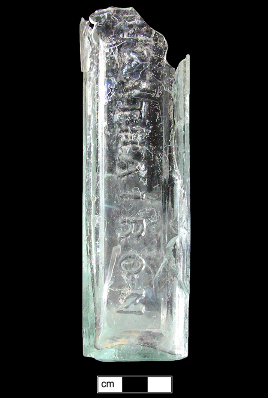 Side view of rectangular light green bottle with molded letters Kathairon.