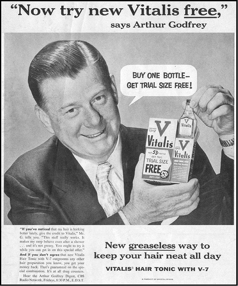 Smiling man in a suit and tie holding a box of Vitalis hair tonic.