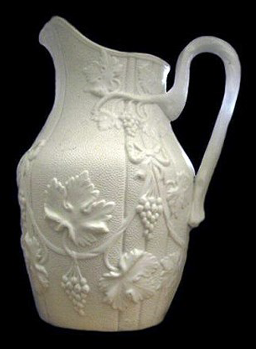 White stoneware mug molded with leaves and grapes.