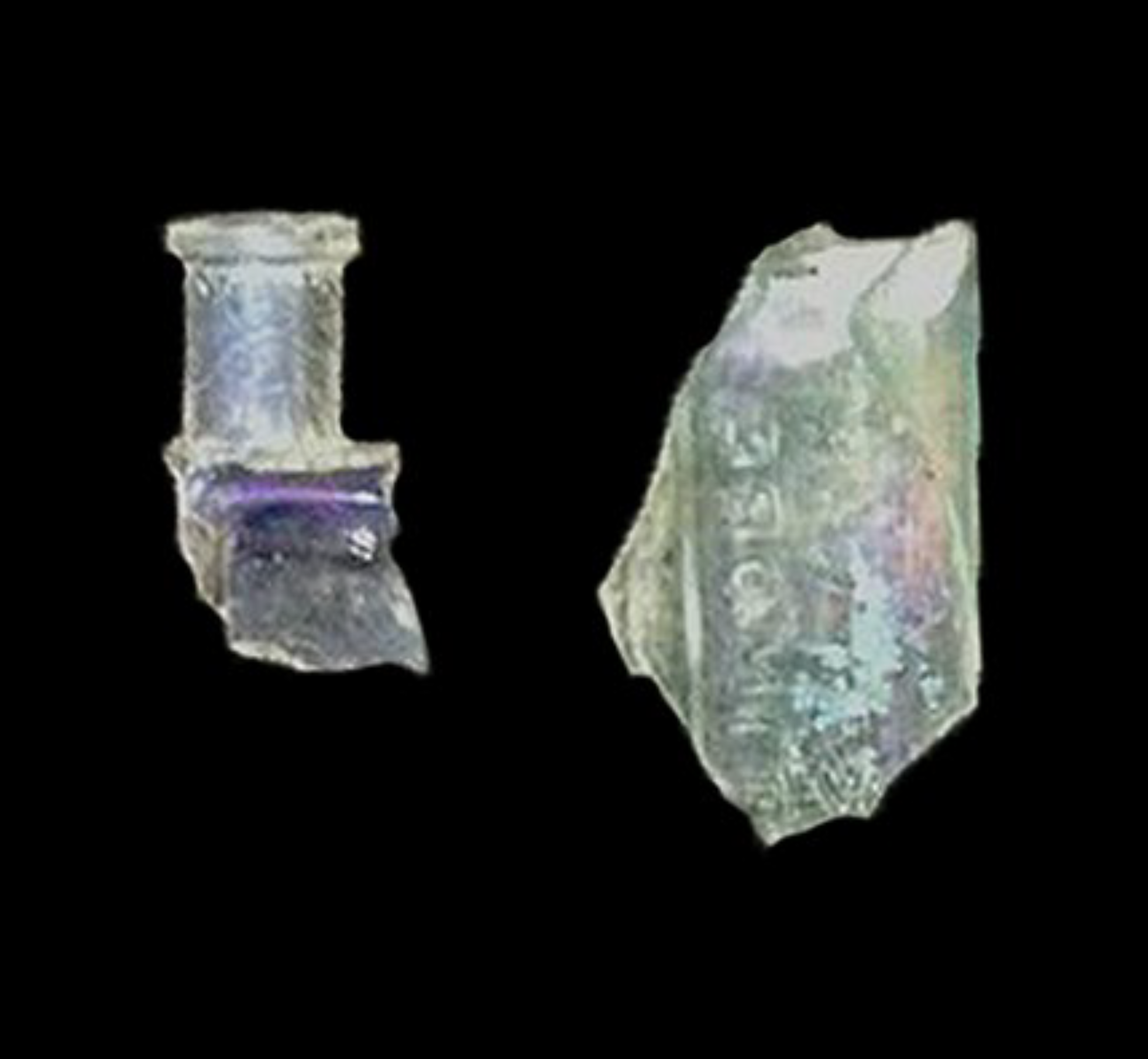 Two fragments of a broken light green peppermint oil bottle.