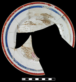 Broken and mended dinner plate with red and blue stripes along the rim.
