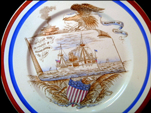Complete dinner plate showing a painted design of the USS Maine on the center of the plate.