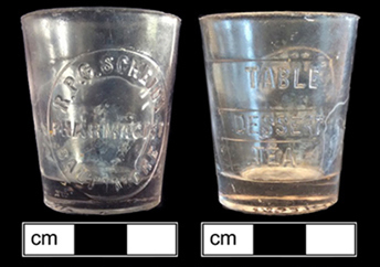 Two images of small glass cup, with writing on the side. The back of the cup has multiple lines along the side, labelled 