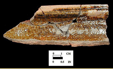Rectangular fragment of brown pottery from a 17th-century basting pan.