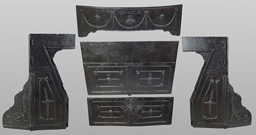 Disassembled cast iron Franklin stove components laid flat showing all individual pieces including decorative top panel with swag garland relief, two paneled door sections, ornate side brackets with scrollwork, and curved base plate, all in black finish against white background.
