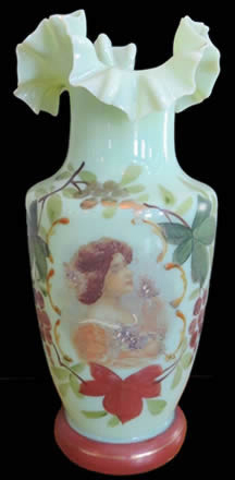 Complete example of a green uranium glass vase painted with a design of a woman and flowers.