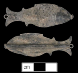 Both sides of copper alloy fish-shaped knitting needle sheath against black background with centimeter scale bar.