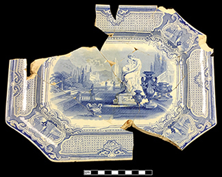 Broken and mended platter with a blue printed design of a classically-attired woman holding a child.