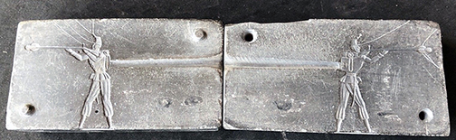 Two-part metal casting mold showing mirror-image cavities for producing flat toy soldiers.
