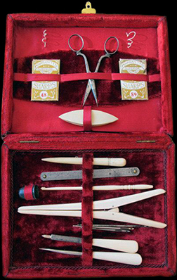 Turn of the 20th century sewing case lined in red velvet and holding a variety of bone and celluloid tools.