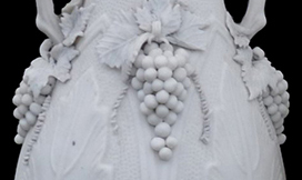 Photograph of complete porcelain bottle, with ornate grapes on the vine ornamentation.