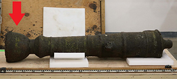 Corroded iron cannon with a scale bar.