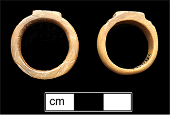 Side views of two carved bone rings.  One has an anchor design and the other a star.