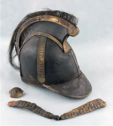 A helmet shaped similarly to a baseball cap with an additional horsehair mohawk
protruding from the top of the cap. An oval copper alloy boss and chin strap decorated
with overlapping metal oval scales lie separated from the helmet.
